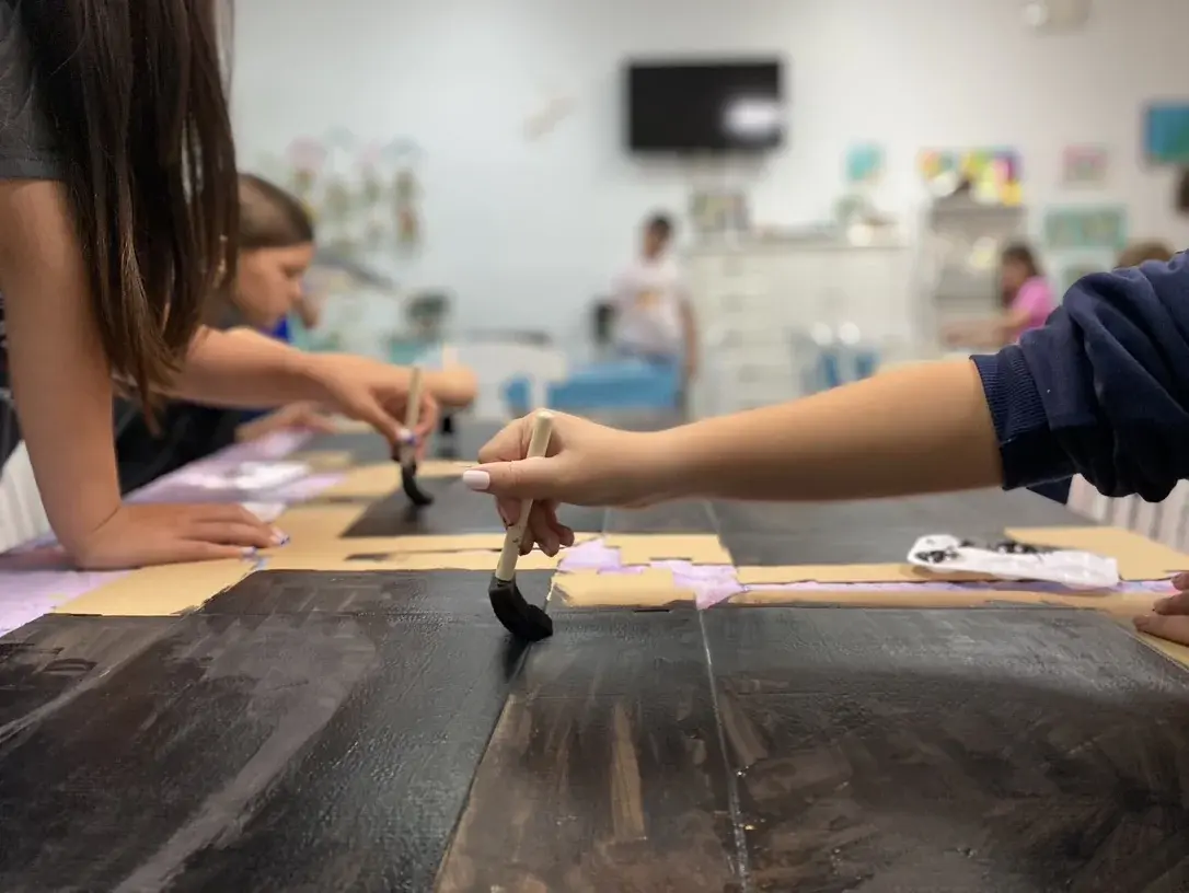 Child painting pottery at Joe Picasso's summer camp